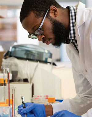 A person wearing a white coat works in a lab.