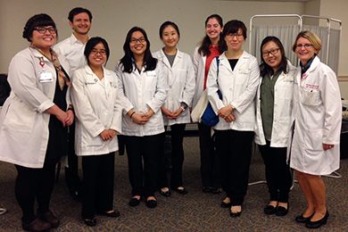 Dr. Nicki Brandt appears to the right of a group of trainees at a local health fair.