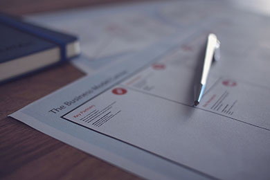 Image of a ballpoint pen that has been placed on top of two documents sitting on a table.