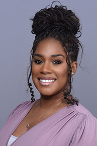 Brittany Harris wearing a light purple top against a plain background