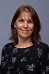 Portrait of Bethany DiPaula indoors against a blue gray background.