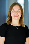 Portrait of Makenzie Harrison indoors against a variegated blue background.